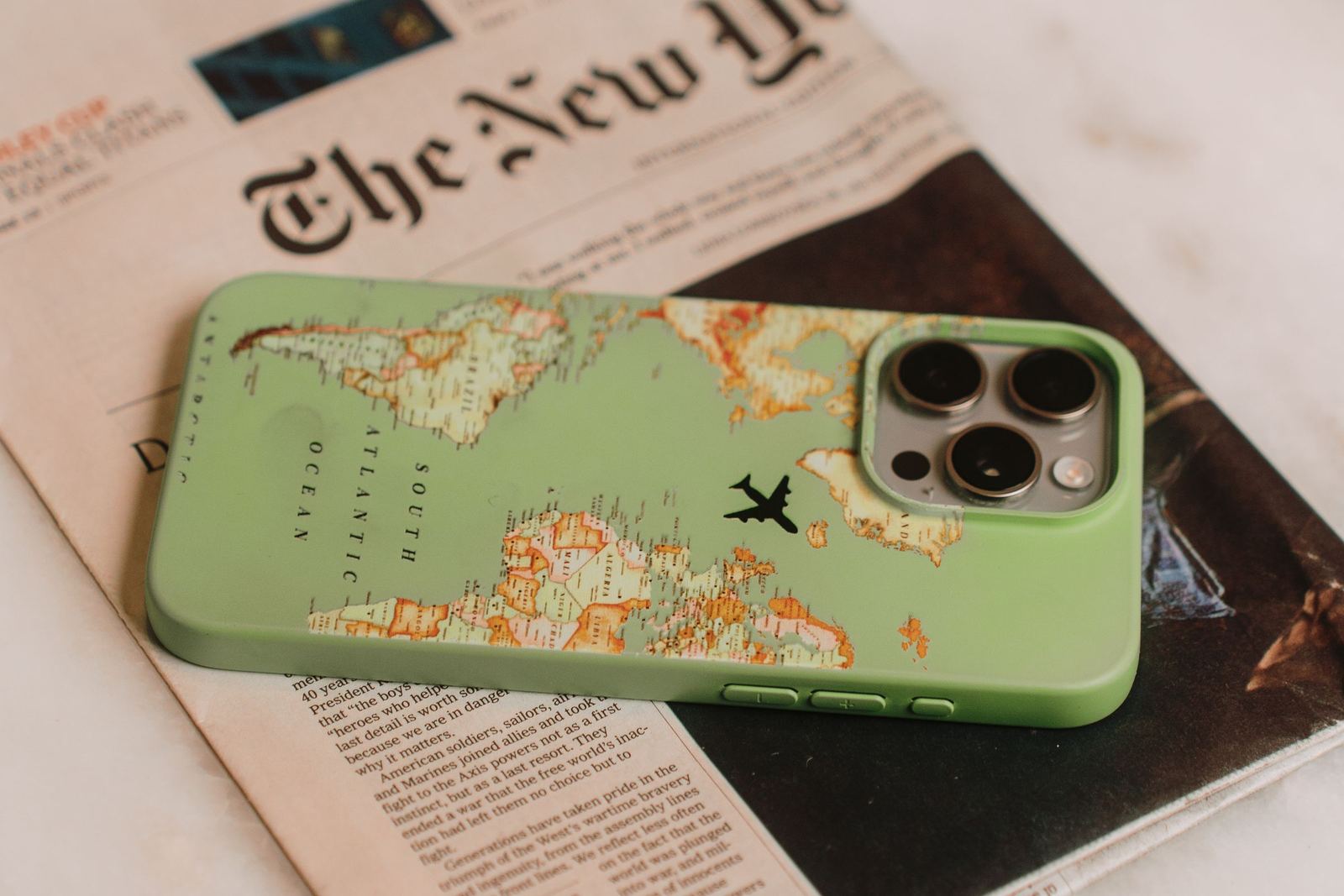A smartphone beside a printed newspaper, showing digital and established media sharing the same space.