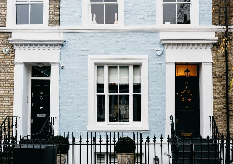 Georgian townhouse facade with black railings and doors in London